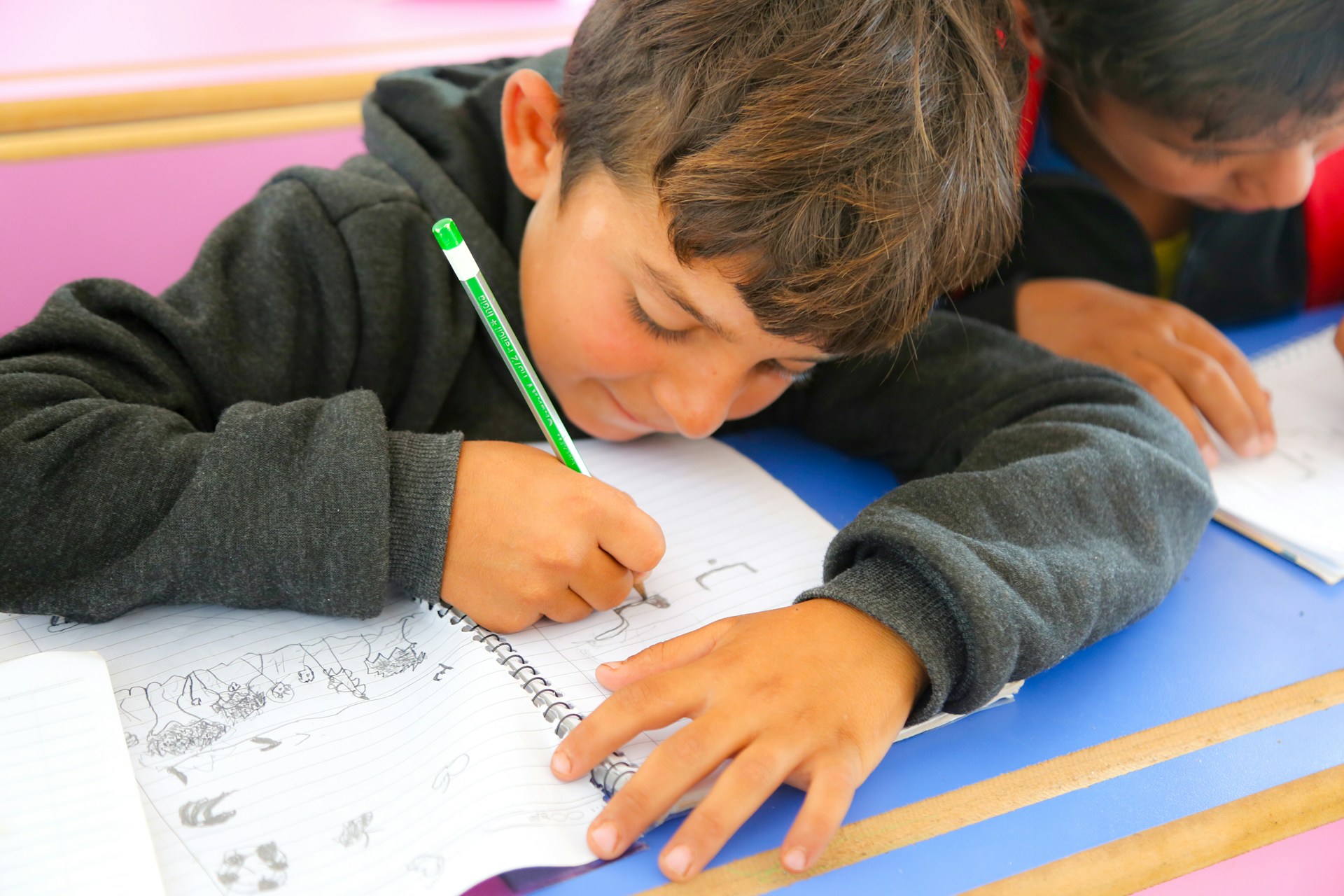 enfant qui dessine dans un carnet